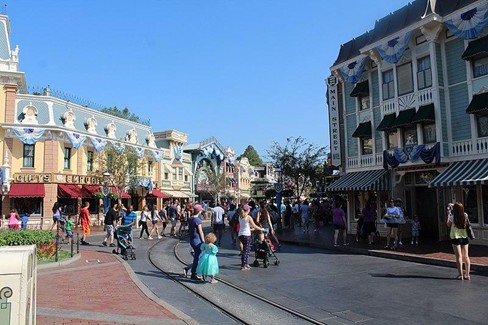 Image shows families walking about Main Street USA at Disneyworld. Image is for illustrative purposes
